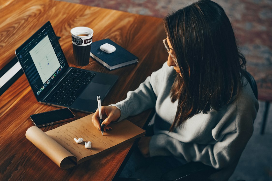 Persona organizando documentos junto a su computadora