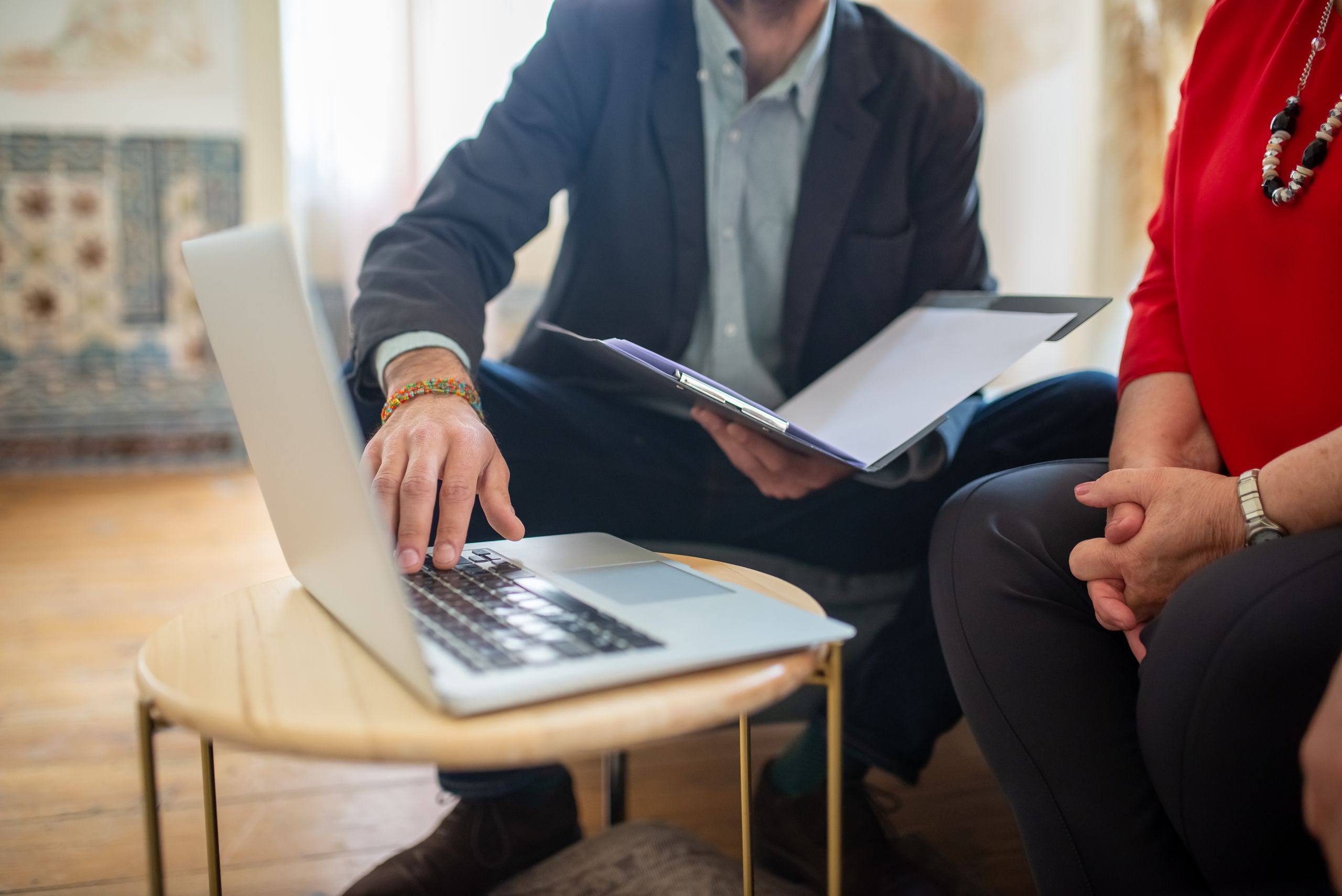 Profissional analisando documentos e usando laptop, representando a tradução de documentos para abrir empresa nos EUA